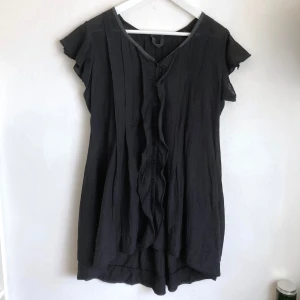 Svart draperad tunika, miniklänning, stl S, bomull, sommar, bohemisk, boho - Svart luftig tunika/miniklänning i bomull. Längre bak, knäppning fram, urtvättad svart. Mått i cm: bröstvidd 49; axelbredd 37; längd fram från axeln 74; längd bak från axeln 82; ärmlängd 10.