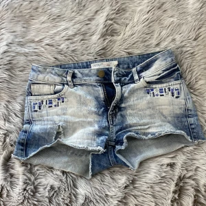 Shorts - Jättefina low waist shorts med mönster framtill. Dom är rivna bak och fram men inte mycket alls🥰