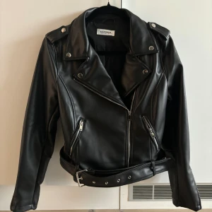 Skinnjacka  - Svarta skinnjacka från Glamorous köpt från Nelly. Endast använd en gång, nyskick! Liten i storlek!