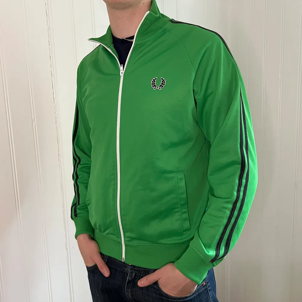 Grön Fred Perry Tracktop | Fint skick | storlek M | Pris 249kr | Modellen på bilden är 187cm | klassisk och snygg supporter tröja | Fraktar via PostNord och Instabox på köparens bekostnad:)  Hör av dig vid frågor och funderingar mvh. Hoodies.