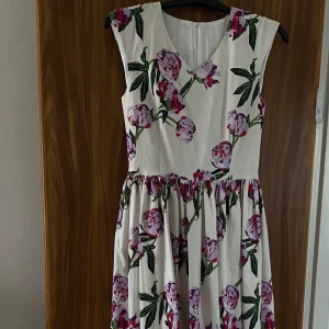 Blommig klänning - Jag säljer denna klänning på grund jag har aldrig använt den, den är ungefär en medium, den är gjord utav bra material : bomull och foder inuti, dessutom är denna hemma sydd så den kommer inte från någon affär/liknade.