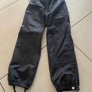 Helly Hansen överdragsbyxor - Överdragsbyxor i fint skick, knappt synligt märke på ena knät men inget som påverkar funktionen storlek 140 (10år)