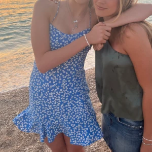 Blå blommig miniklänning - Säljer min blåa blommiga miniklänning från zara. Använd väldigt sparsamt så är i väldigt bra skick. Banden korsas i ryggen vilket är väldigt snyggt!! Storlek XS. Pris 240. Passar bra för folk över 160 skulle jag säga🩵🩵