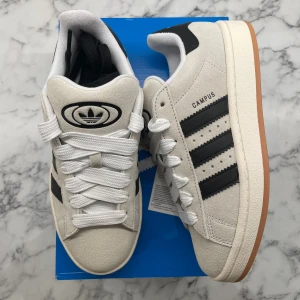 Adidas Campus 00s ”Crystal White” - Helt nya och oanvända Adidas Campus 00s ”Crystal White”. Storlek: 39 1/3. Pris: 1549. Skicka ett meddelande vid intresse. Köp tryggt och snabbt hos oss. Många nöjda kunder😊