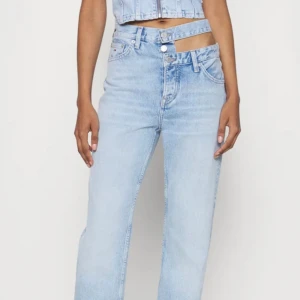 Jeans med hål vid midjan - Jättefina jeans med hål vid midjan (som första bilden fast på båda sidor). Ifrån Nelly. Ser ej storlek men passar mig som har 36/38.