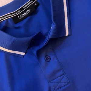 Blå träningspiké - Aldirg använd aldirg tvättad. Blå piké i träningsmaterial från tenson.