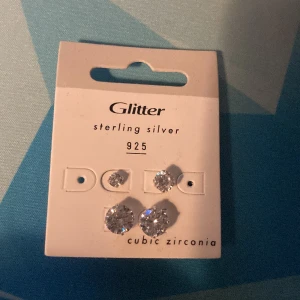 Örhängen  - Dem är INTE  använda på ett tag så säljare dem dem är i plast eller glass vet inte riktigt kanske silver 