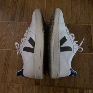 Veja v-10  - Säljer ett par vita sneakers i gott skick. Storlek 42. Modellen heter Veja v-10 white/kaki indigo. 