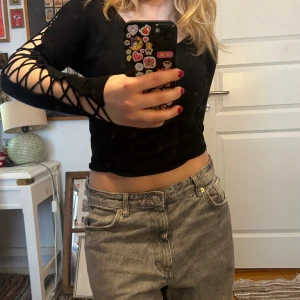 Festtop - Jättesnygg svart tröja med snörning på ärmen. Bra skick, knappt använd.   