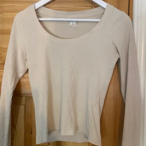 Beige topp - En beige, ribbad och långärmad topp från Monki. Säljer eftersom den inte kommer till användning. Skicket är bra, har använt men det finns inga defekter eller liknande!😊