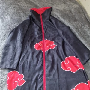 Akatsuki kappa xl  - Säljer kappan från nördmarknaden. XL. Längd 108cm. Midja 90cm typ. Fin röd dragkedja. Moln bak. Säljer då jag hittat en mindre. Möts i Gbg. Nypris 500kr. Säljer för 360kr eller byte med en sak.