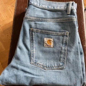 Ljusblåa Carhartt Newel stl 29 - Carhartt jeans i rak modell W29 normal i stl Mycket sparsamt använda endast tvättade en gång Nypris 1199kr 