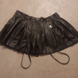 Svart fakeläder kjol med hängslen/remmar - Storlek; XL/LARGE (insydd av någon från 2XL)