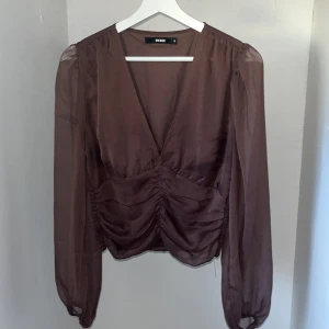 Brun mesh topp - Brun mesh topp med v-ringning och med stretchigt tyg på nedre delen av ryggen. Använd fåtal gånger och fortfarande mycket bra skick