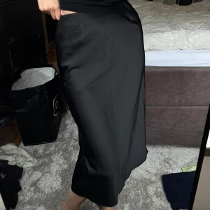 Uniqlo svart midikjol - Superfin. Knappt använd från Uniqlo passar till vardags men också finare tillfällen!