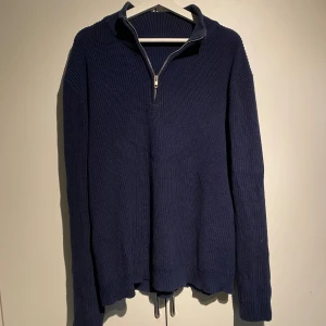 Marinblå stickad Half Zip - Hej, säljer en stickad marinblå half zip unbranded. Storlek L och true to Size. Köpte för 600kr här på Plick. Använd en del men bra skick utan defekter. Perfekt över skjorta eller pike. Pris kan diskuteras. Hör av dig vid intresse. 