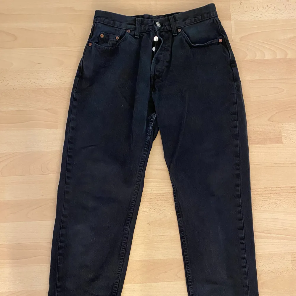 ett par svarta levi’s jeans. lite tecken på användning då byxorna har lite uppslitningar mellan låren men inga hål. Jeans & Byxor.