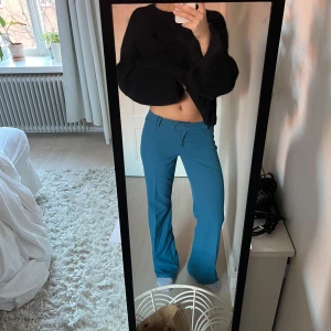 Lågmidjade kostymbyxor  - Lågmidjade kostymbyxor i en fin blå färg. Jag är 174. Knappen längst upp saknas 