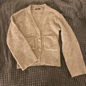 Finstickad cardigan - Superfin och mysig cardigan i beige med knappar. Är i storlek Xs men passar S. Köpte men kom aldrig till användning☺️