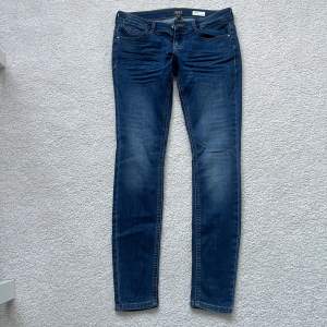 Blåa lågmidjade jeans i nyskick från ONLY ”Blue Denim anne 1995”. Coral Super Low Skinny. Använda 2 gånger. Storlek 27/30 ,ordinare pris 449