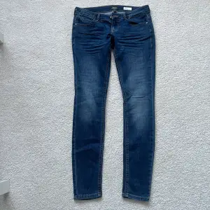 Blåa lågmidjade jeans i nyskick från ONLY ”Blue Denim anne 1995”. Coral Super Low Skinny. Använda 2 gånger. Storlek 27/30 ,ordinare pris 449