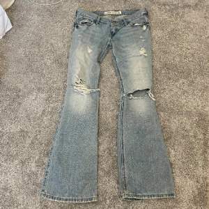 Säljer dessa ljusblåa lågmidjade bootcut jeans med slitningar. Midjemått: 76cm Innebenslängd: 78cm. Har ingen bild på då de är för små. Har du någon fråga är det bara att höra av dig🫶🏻