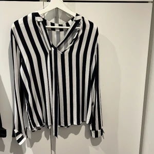 Blus  - Randig svart/vit blus med knyte bak