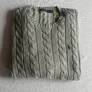 Kabelstickad Ralph Lauren - En populär grå kabelstickad Ralph Lauren tröja i bra skick. Nypris ligger på runt 2200kr. Hör av dig vid frågor!