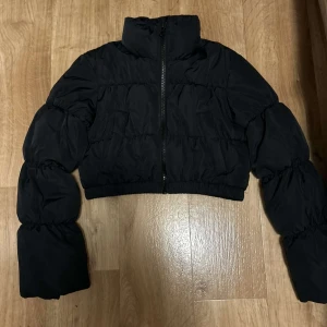 Vinterjacka från H&M storlek XS - En svart vinterjacka från H&M divided i storlek XS. Kort modell med ”puffiga” armar (utan luva). 