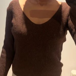 Stickad tröja - Brun tröja som är stickad.