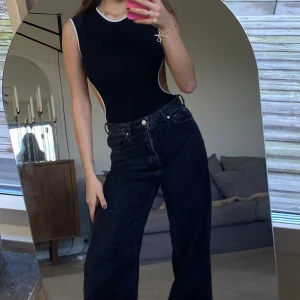 Body med öppenrygg - Säljer min SÅ snygga body i svart med vit ytterkant! Älskar att den är öppen i ryggen🤍🖤