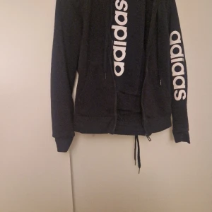 Mjukisset - Ett adidas mjukisset som är i bra skick. Den har ett jättefin marinblå färg med en vit text.