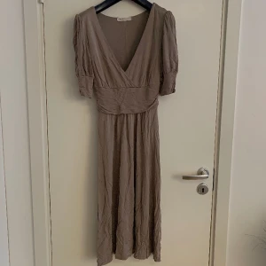 Kortärmad klänning - Flowig klänning by Madonna. 