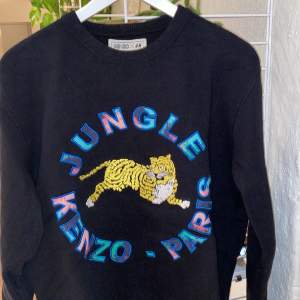 Sweatshirt i svart med broderat tryck från den exklusiva kollektionen Kenzo X HM. Använd fåtal gånger. Skön fleece på insidan. 