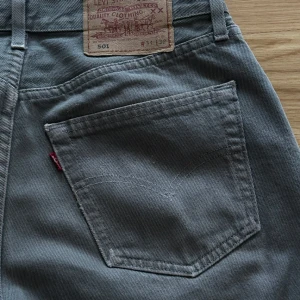 Grå 501 Levi’s - Grå 501 Levisjeans Storlek: W31, L32 Skick: Använda fåtal gånger. Defekt: En pytteliten rödmarkering på ena byxbenet (köpte dem så). Därav priset.   Frakt står köparen för. 