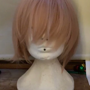 Rosa peruk med tofsar! - TRYCK INTE PÅ KÖP NU!! Peruken är i helt okej skick men tofsarna har sätt bättre dagar! (Kläman på ena är sönder men kan bytas ut) Kom gärna med pris förslag och frågor 😊