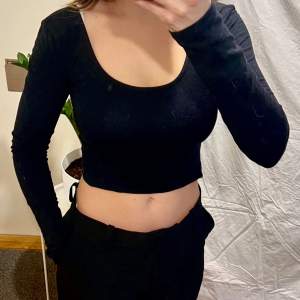 Black long sleeved crop top with cross cutouts on back