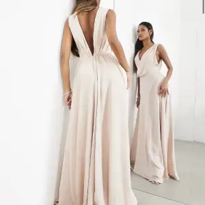 En vacker satin klänning i storlek 38. Modellen är 171 cm. Klänningen är från Asos och är i färgen puderrosa. Materialet är 100% polyester med väldigt fina detaljer på både fram och baksida. Klänningen är i fint skick. För ytterligare bilder, skicka dm