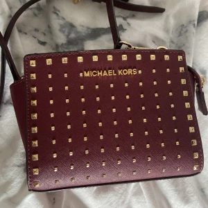 Michael kors axelremsväska  - Jätte snygg vinröd Michael kors väska som inte kommit till så mycket användning! Väskan har en rem som man kan ta av och på💞Knappt använd och nästan som ny. (Kom privat för frågor o funderingar).❤️Kan mötas upp i Stockholm!!