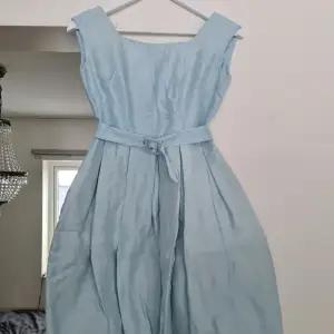 Vintage klänning från 50-talet. Ljusblå med ett skärp i midjan. Innerkjolen är i ett hårt material för att få en puffigare nederdel. Dragkedjan är trasig och skulle behöva bytas, annars i jättefint skick. Storleken är 36 men skulle säga 32-34, XXS/XS