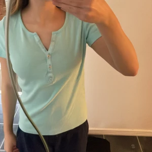 Turkos tröja med knappar - En turkos t-shirt med knappar. Den är från Kappahl och är i storlek s men passar med xs.💞💞