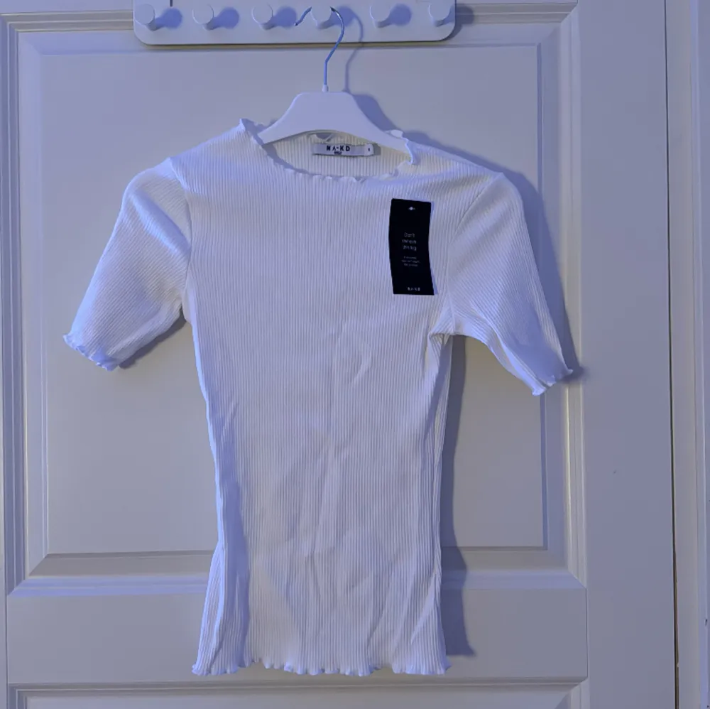 En vit ribbad tshirt från nakd i storlek xs med lappen på. Helt oanvänd. . T-shirts.