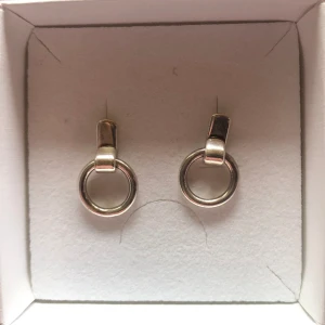 Örhängen - Silvriga örhängen, aldrig använda. Osäker på vad det är för material, men skulle tro silver