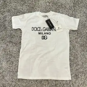 Helt Oanvänd Dolce Gabbana t-shirt i storlek 12-13. 10000-10 skick eftersom den är helt oanvänd. Köpt i farfetch som helt ny för €251 vilken motsvarar cirka. 2500kr som nypris. Mitt pris: 1200kr. Det kan diskuteras och prutas rejält vid snabb affär. 
