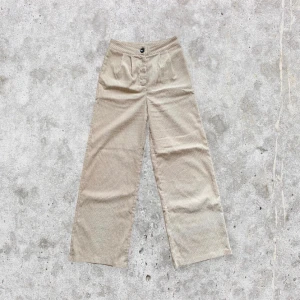 Vida högmidjade kostymbyxor - Ett par snygga vida högmidjade Manchester liknande kostymbyxor i beige färg. Storlek S. I fint skick. För fler bilder eller mått kontakta mig :)