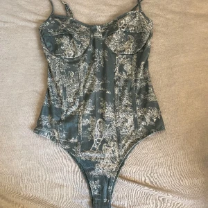 Grön detaljerad body  - Säljer min jättefina gröna body från cider. Bara använt en gång så är i mycket bra skick. Justerbar på linnets ”armar”. För fler bilder skriv till mig privat. Står inte vilken storlek det är men är rätt så säker på att det är XS eller S!❤️