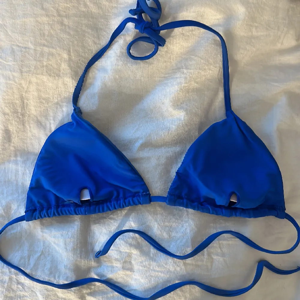 Superfin blå bikiniöverdel som säljs pga för liten storlek. Den är något solblekt på framsidan men är fortfarande i väldigt gott skick och snygg färg. Skulle säga att den passar en xs/s. Övrigt.