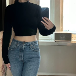 Svart topp med öppen rygg  - En svart topp med högre krage i halsen, öppen i ryggen med ett snöre du knyter baktill 