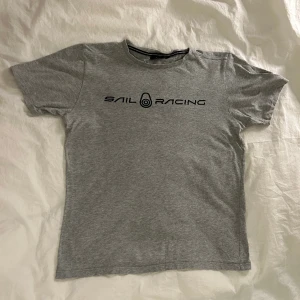 Sail Racing T-shirt  - Denna T-shirt är av märket Sail Racing. T-shirten har används varsamt och är i bra skick. Säljer detta plagget eftersom den har blivit för liten. Plagget har storleken 170 men passar för folk som bär XS