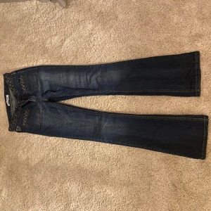 Jättesnygga Lois Jeans - Jättesnygga bootcut Lois jeans som är Lowwaist. Jätte fina unika detaljer. Säljer då de är lite för tighta för mig! Lite slitna. Pris kan diskuteras.